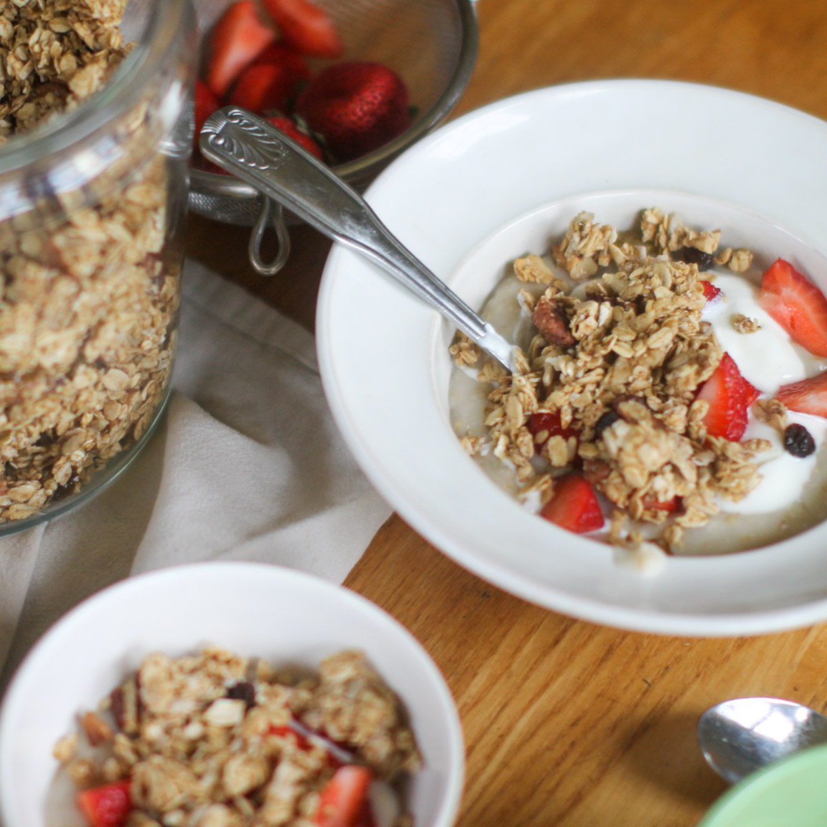 Breakfast bowls topped with homemade applesauce granola and berries with yogurt.