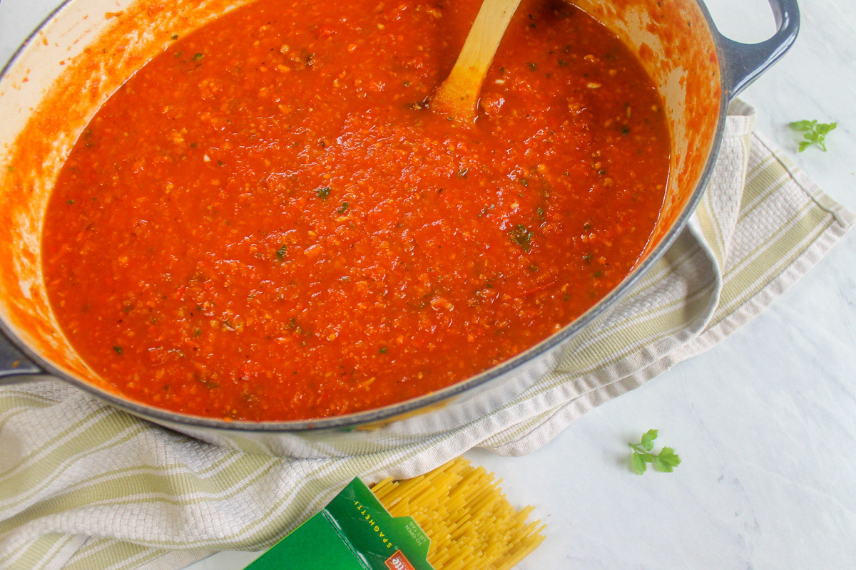 Italian Sausage Bolognese Sauce next to a box of opened pasta.