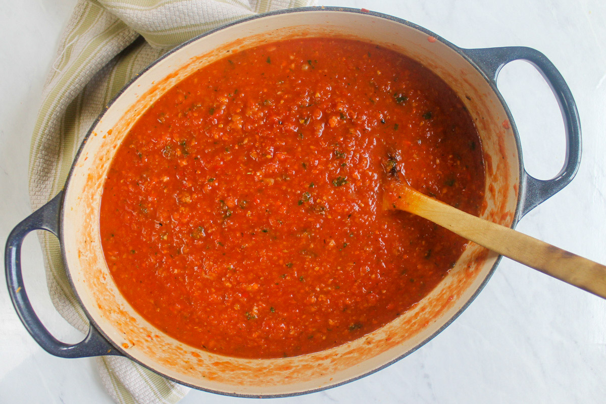 Italian Sausage Bolognese Sauce in a pot with a wooden spoon.