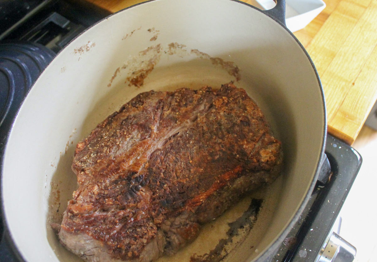 Searing the beef roast in a Dutch oven.