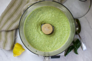 A food processor with the blended avocado bean dip.