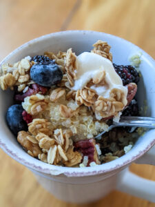 Power breakfast quinoa bowl topped with blueberries, yogurt and granola.