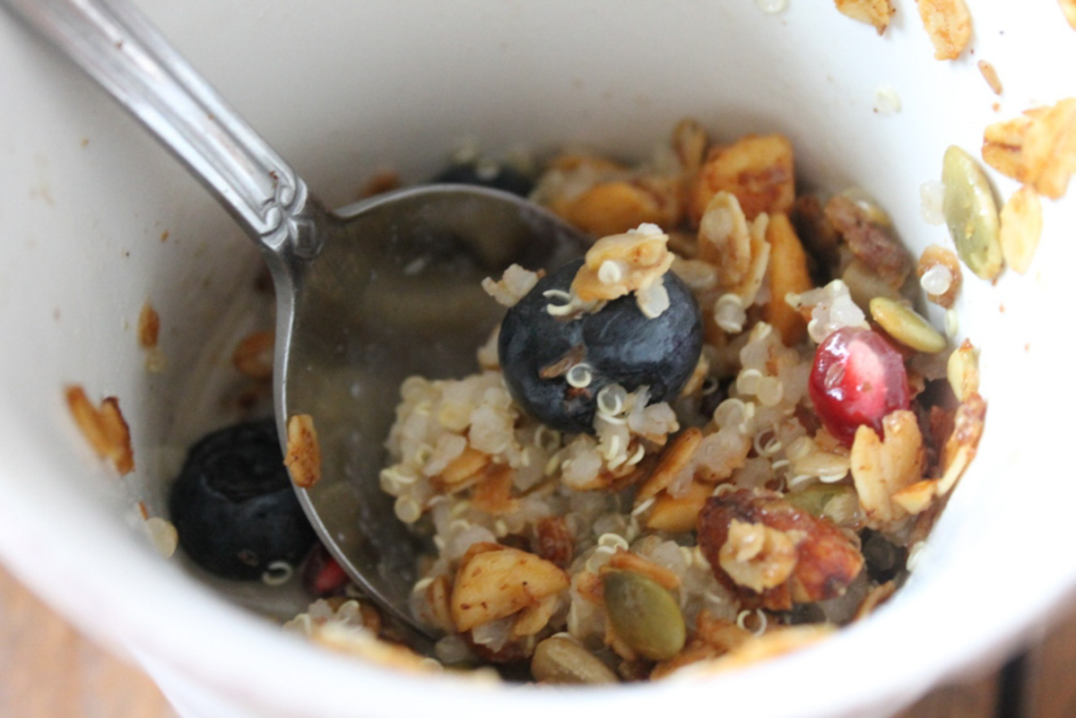 Leftover quinoa for breakfast heated with milk and topped with granola, pomegranate seeds and blueberry.