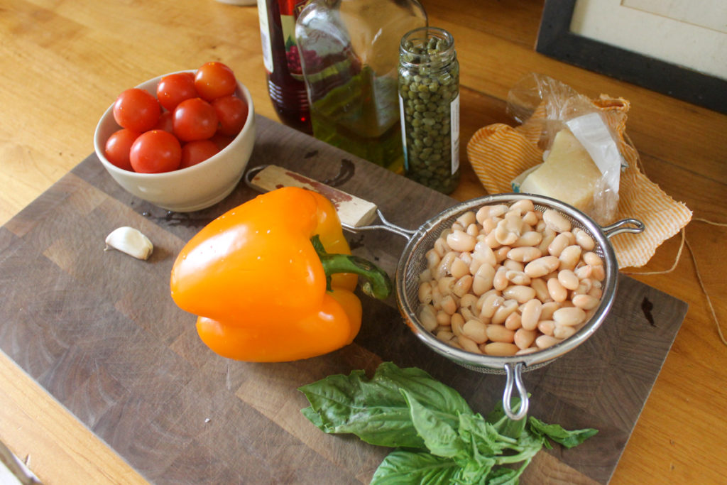 White bean bruschetta ingredients on a cutting board.