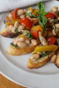 A plate of white bean and roasted garlic bruschetta on toasted crostini.
