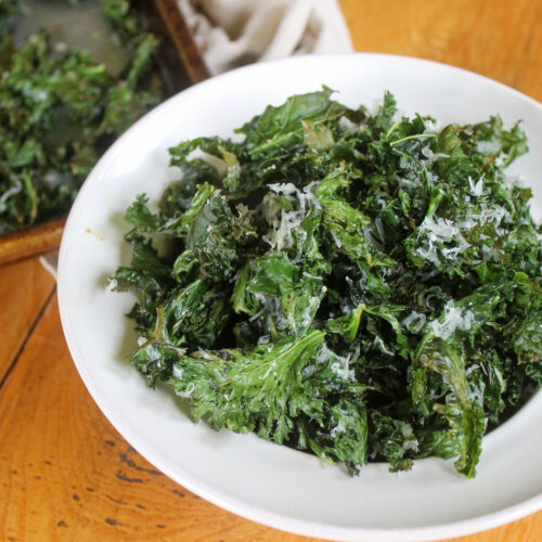 A white bowl of parmesan kale chips.