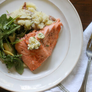 A plate of wild caught baked salmon with garlic honey butter.