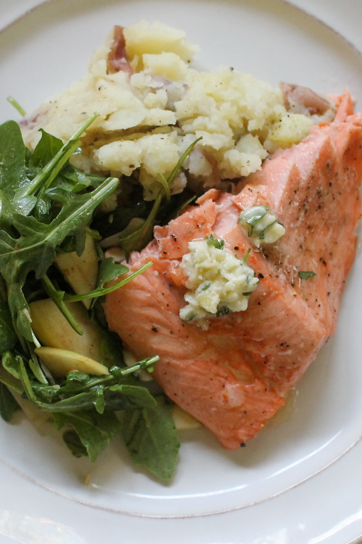 Roasted garlic honey butter salmon with mashed potatoes and salad.