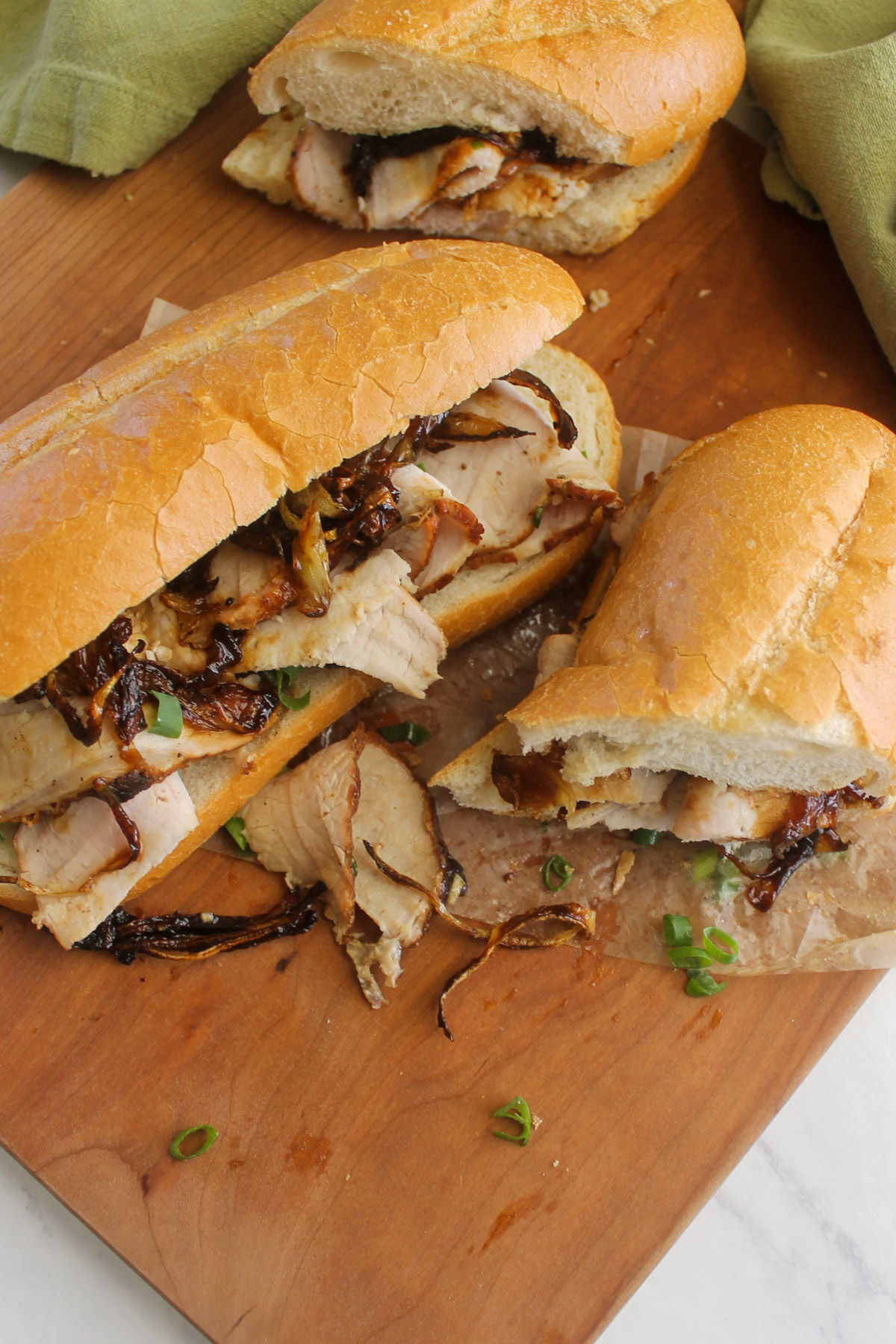 A shaved pork roast sandwich with onions on a hoagie roll.