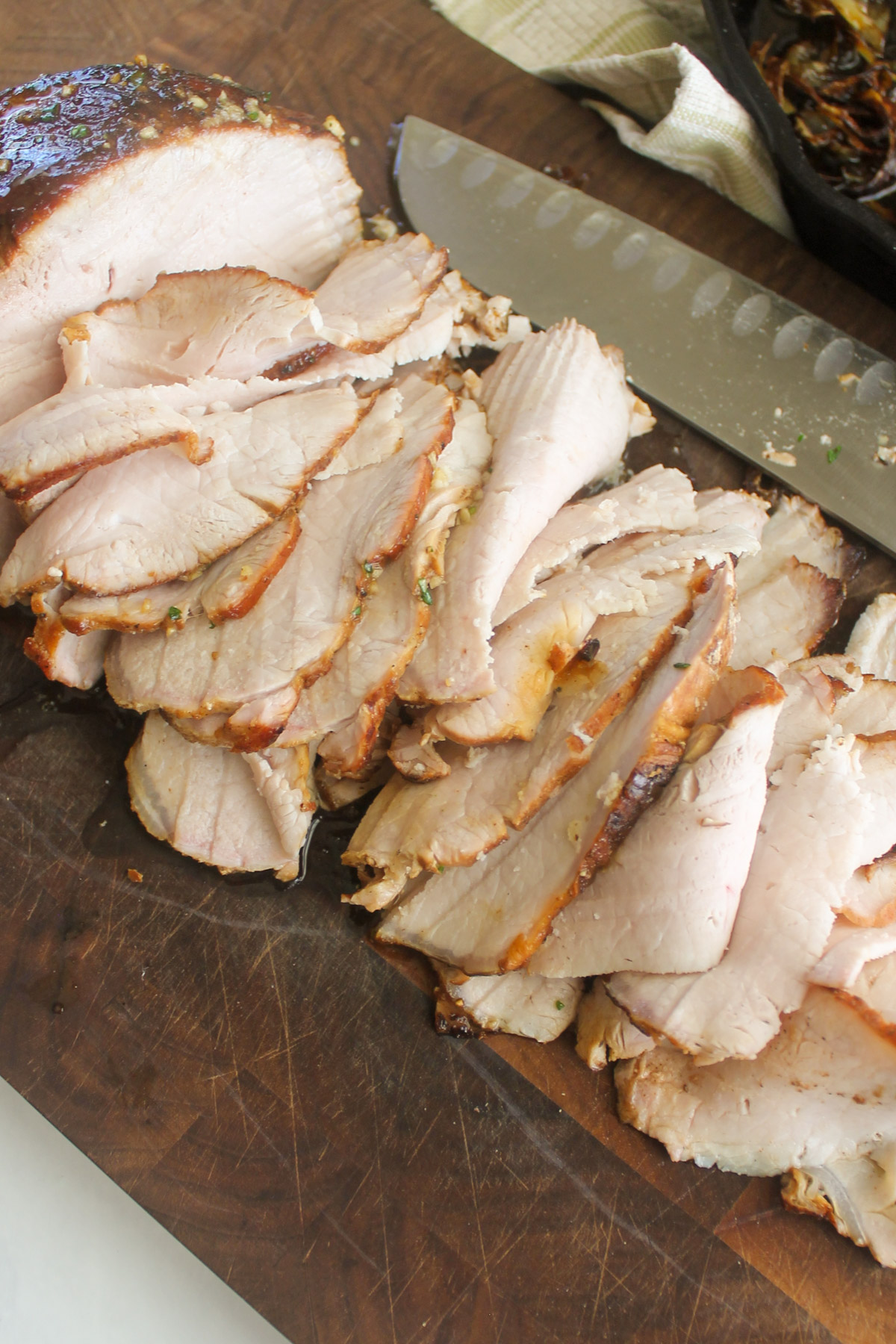 Shaved pork roast on a cutting board.