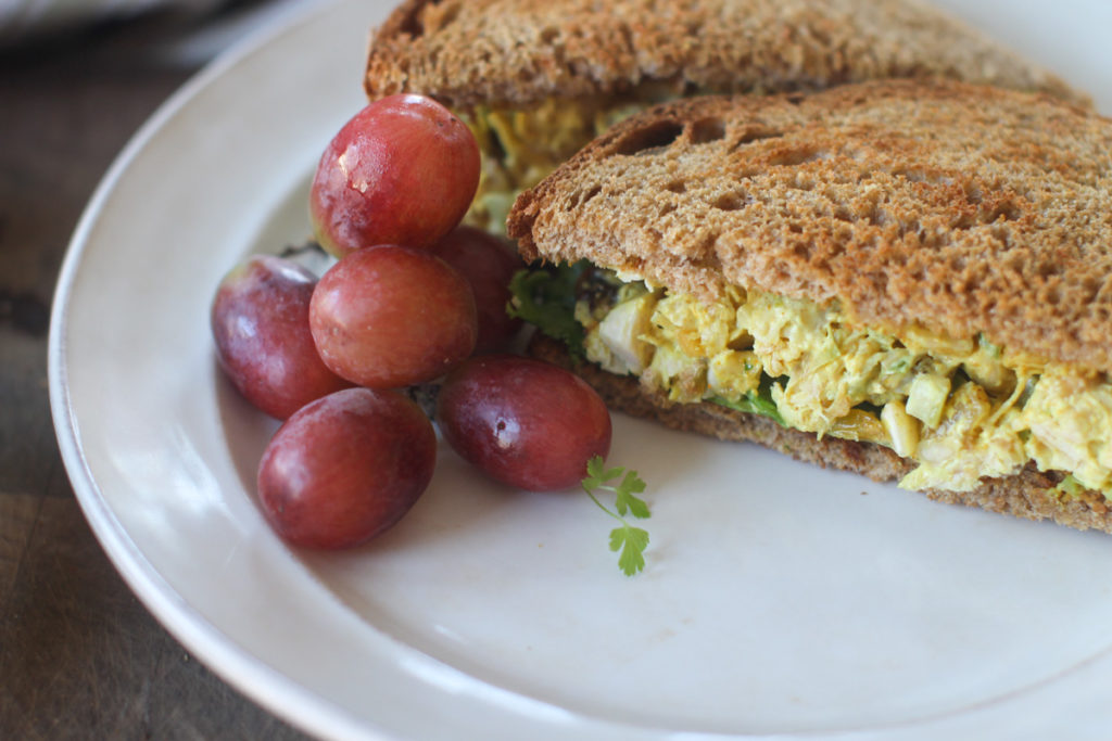 Curry Chicken Salad Sandwiches served with red grapes.