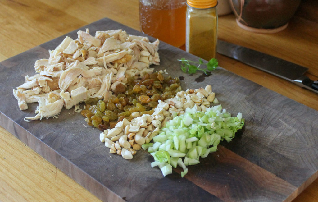 Curry Chicken Salad Ingredients chopped on a cutting board.