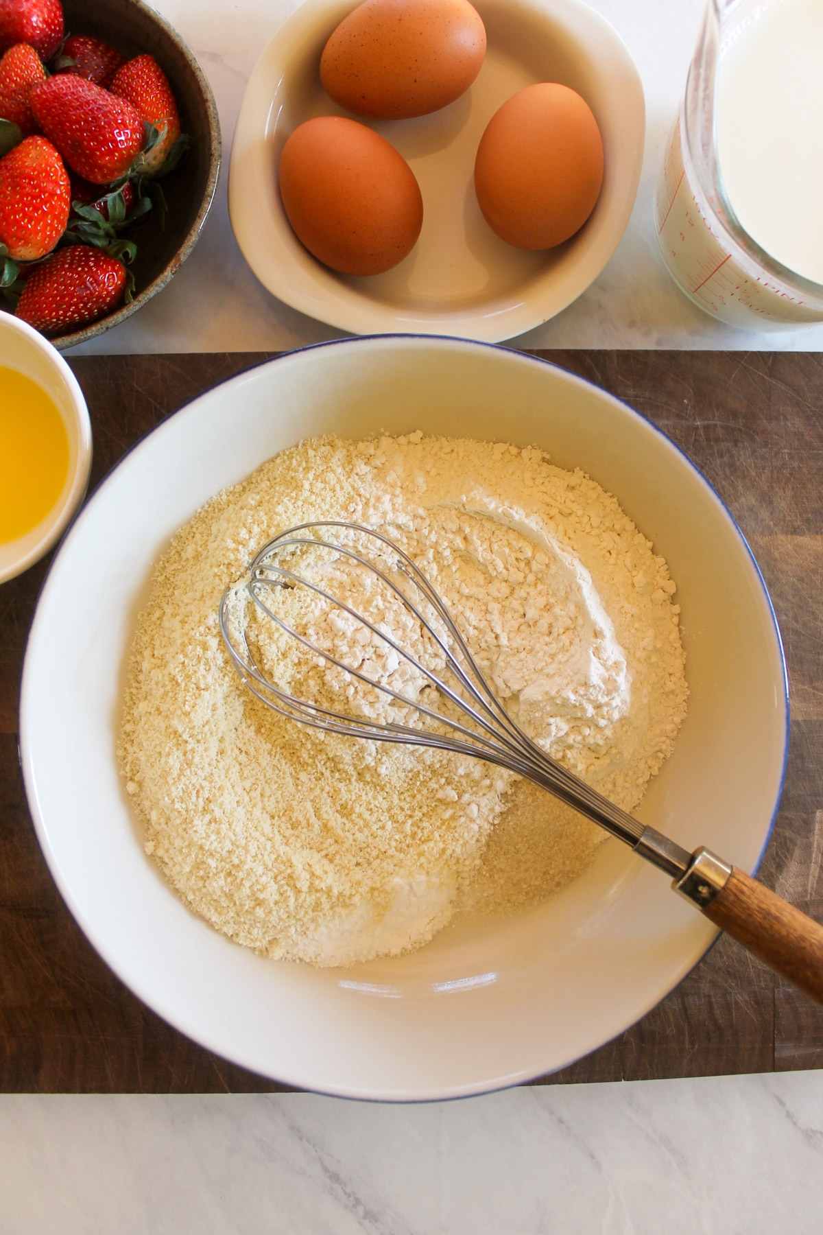 Mixing the dry pancake ingredients in a bowl with a whisk.