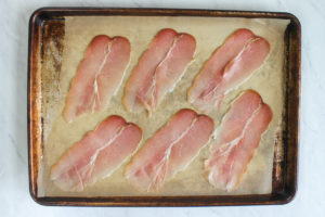 Prosciutto on a baking sheet pan, ready to bake.