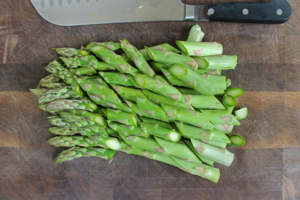 Bias cut asparagus on a cutting board ready to blanch.