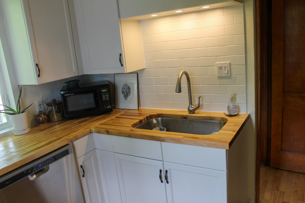 Kitchen renovation with new white subway tile backsplash sink area.