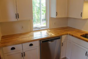 New butcher block countertops and stainless steel dishwasher.