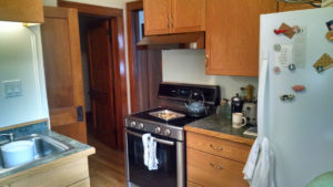 Before picture of stove area with old oak cabinets.