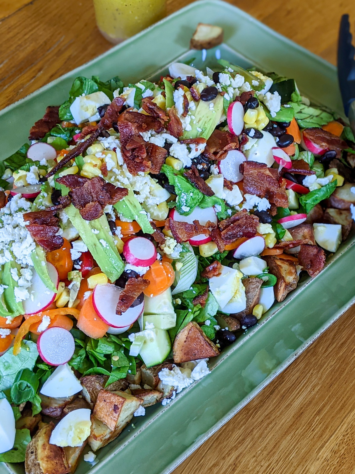 A large salad for dinner with roasted potatoes, bacon, avocado and lots of veggies.