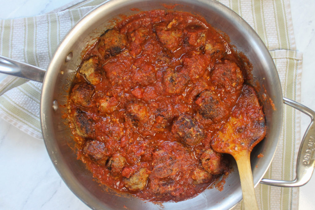 Meatballs simmering in marinara sauce