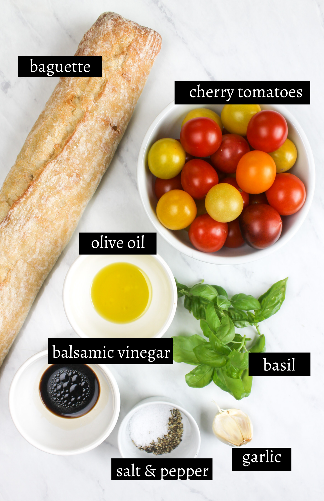 Labeled ingredients for bruschetta with cherry tomatoes, basil, garlic, baguette, oil and vinegar.