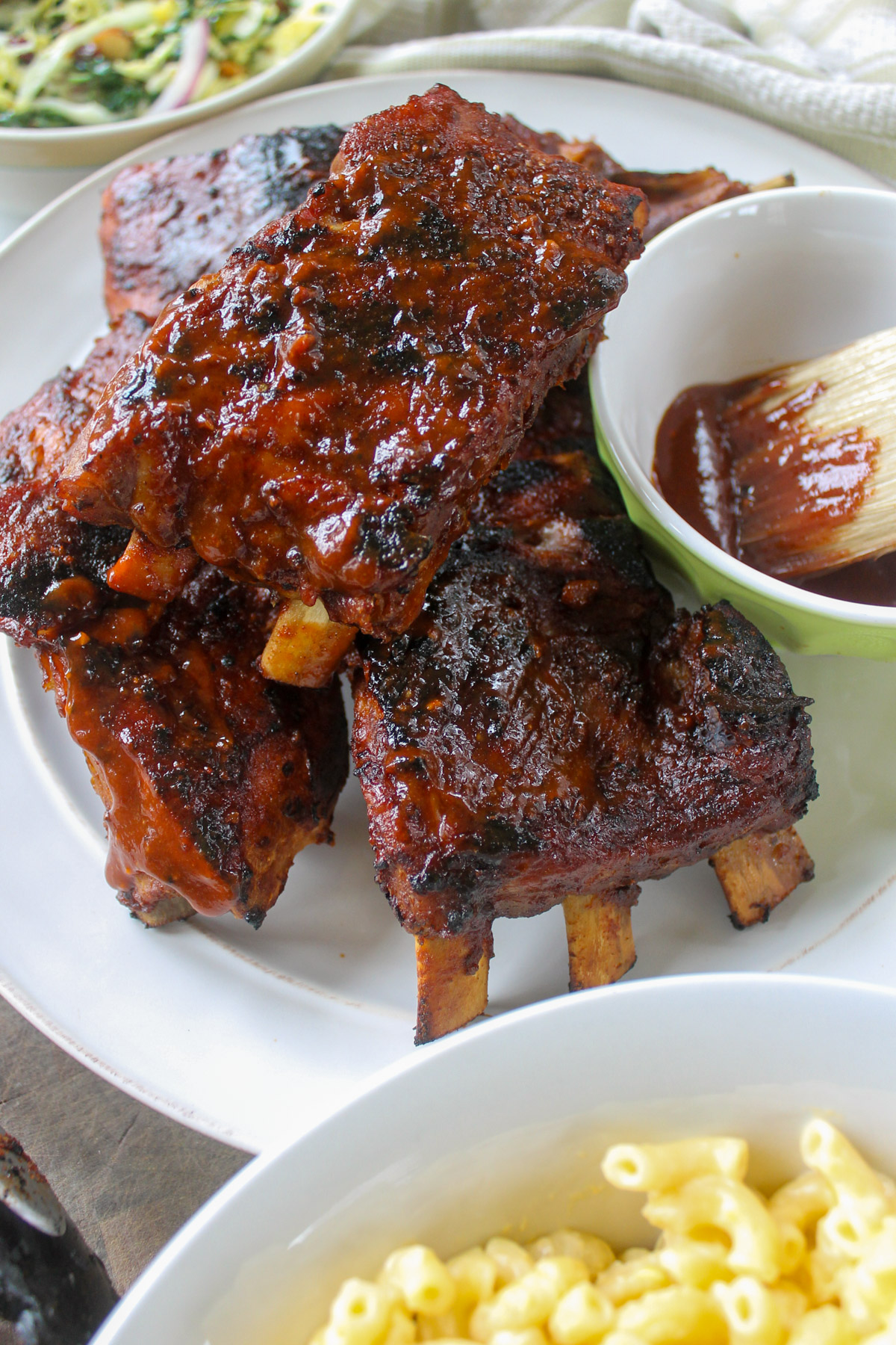 Dry rub ribs that have been baked and then grilled with a bowl of extra bbq sauce.