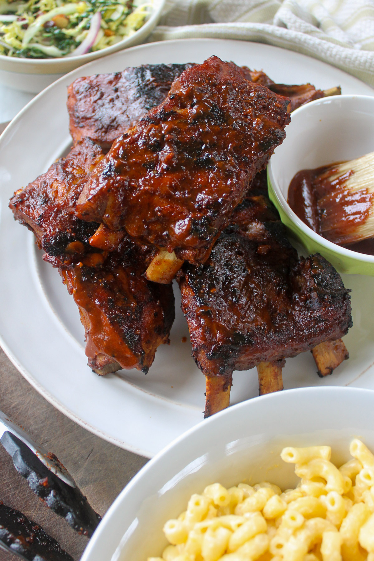 Dry rub ribs that have been baked and then grilled with a bowl of extra bbq sauce.