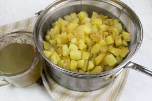 Potatoes for chowder are boiled in a separate pot and drained, saving the starchy cooking liquid to add to the soup.