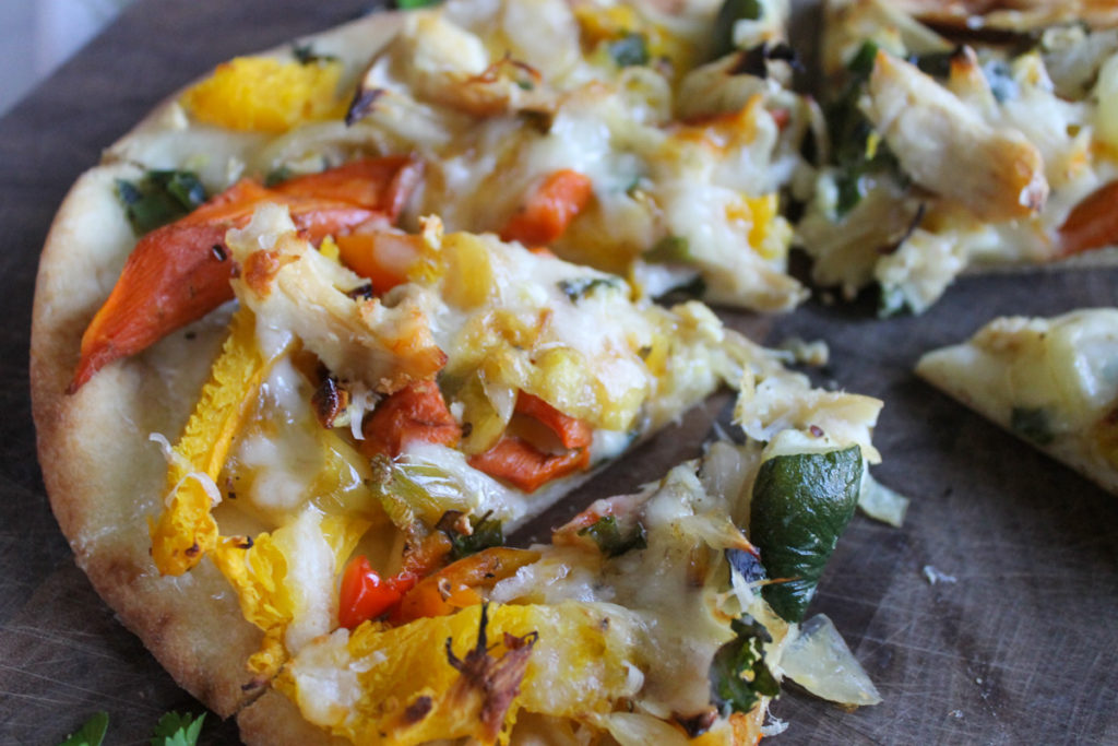 Naan pizza flatbread with roasted vegetables.