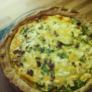 Sausage and fresh spinach quiche with feta cheese.