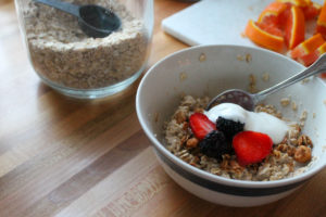 Homemade instant oatmeal bowl topped with berries yogurt and granola.