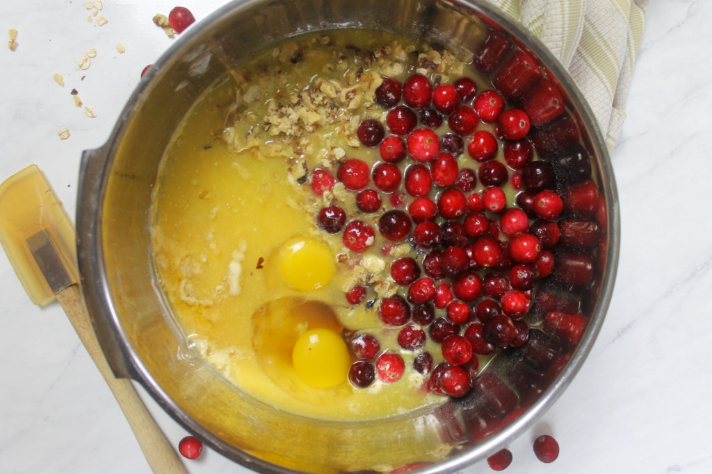 A bowl of all ingredients for Cranberry Muffins to mix into batter.