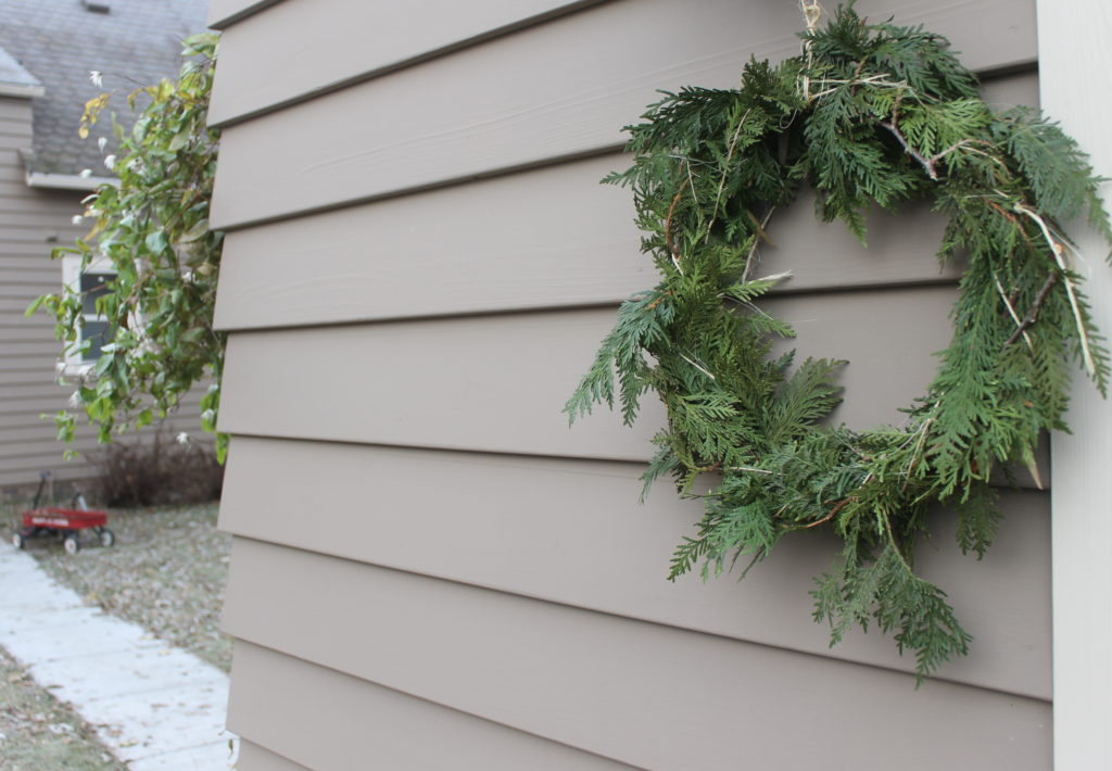 A handmade wreath hanging on a house.