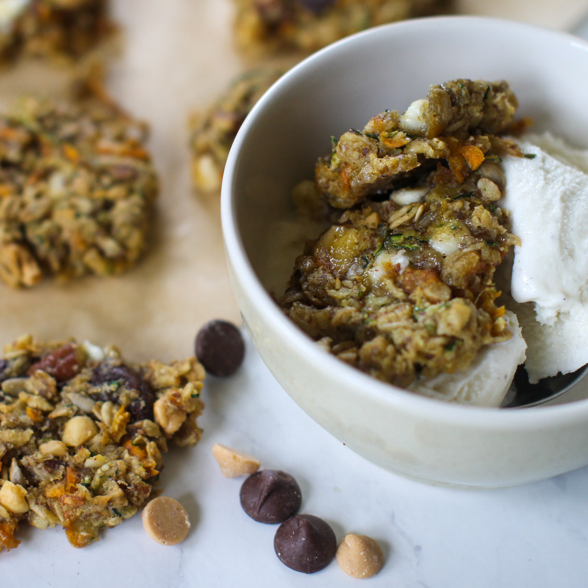 A bowl of vanilla ice cream with zucchini banana cookies and chocolate chips.