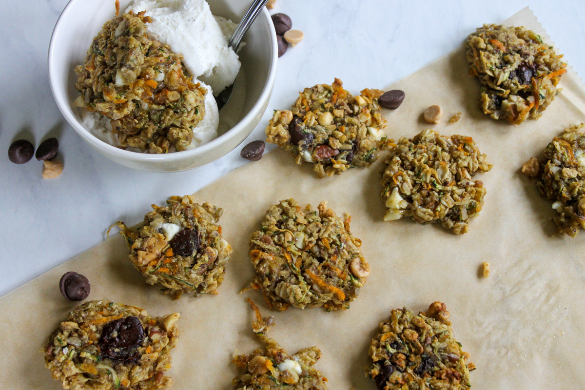 A small bowl of ice cream topped with banana zucchini cookies and more cookies on the counter.