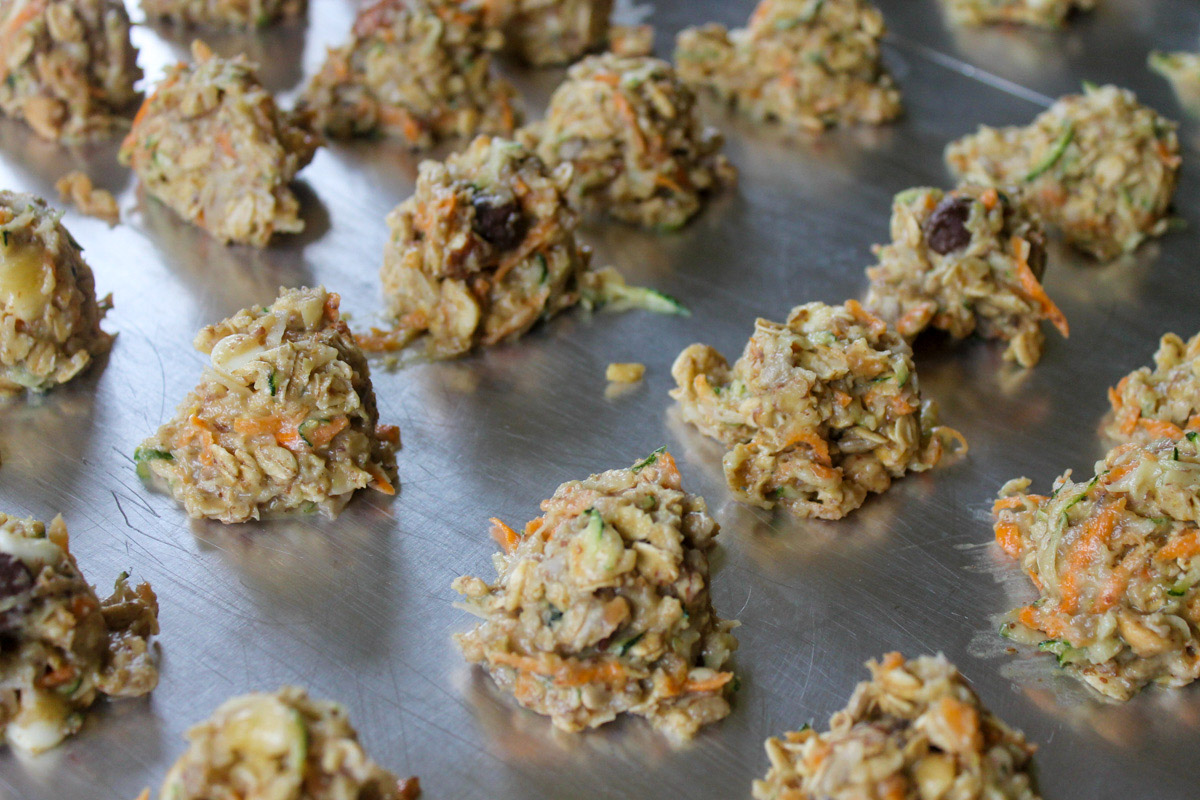 Raw zucchini cookies on a  cookie sheet pan ready to bake.
