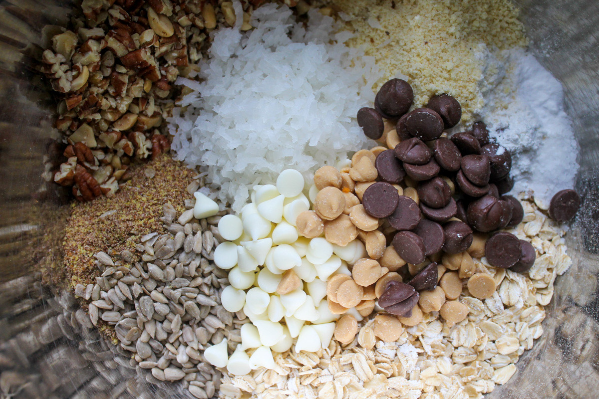 A bowl of zucchini cookie ingredients, oats, nuts, seeds, coconut and chocolate chips.