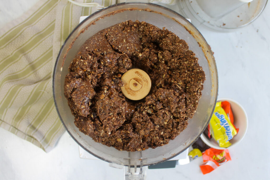 All ingredients for peanut butter nutella protein balls blended in a food processor.