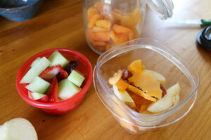 Healthy kids snacks filled with melon, strawberry, grapes, cheese, apple and dried apricot.