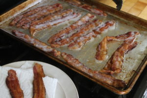 Bacon cooked on a sheet pan in the oven.