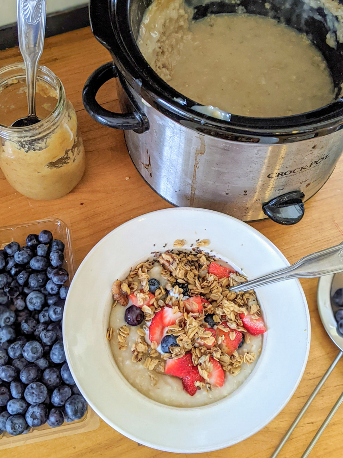 A bowl of crockpot steel cut oatmeal with granola and berries.