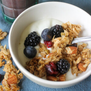 Kid's bowl of yogurt with homemade granola and berries.