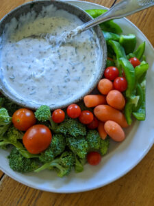 A plate of raw vegetables and dip as a dinner side dish for kids.