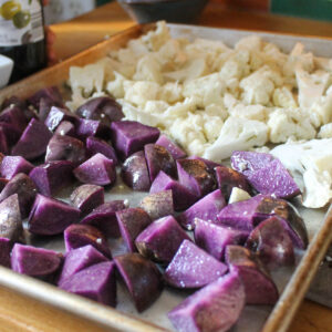A sheet pan of cauliflower and purple potatoes to roast.