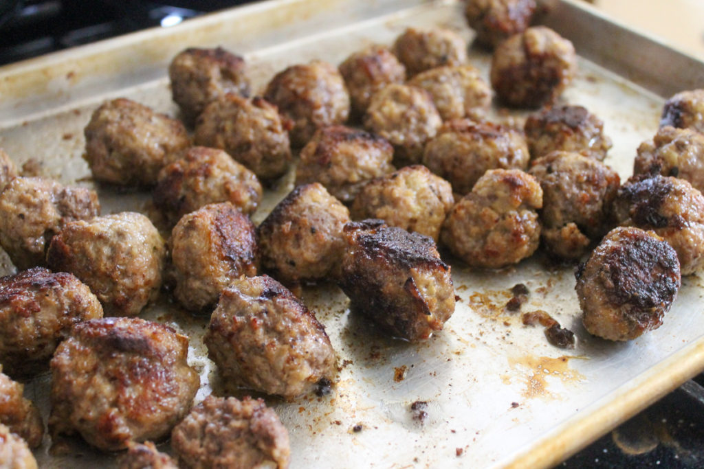 A sheet pan of meatballs baked in the oven.