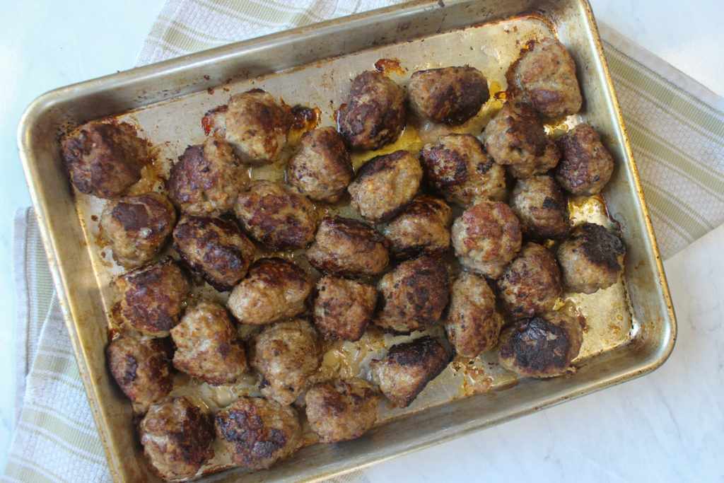 A sheet pan of the baked meatballs.