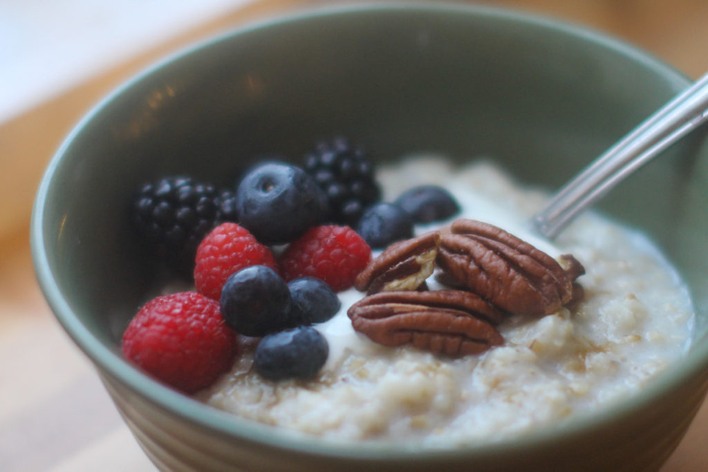 Crockpot Steel Cut Oatmeal topped with berries, pecans and yogurt