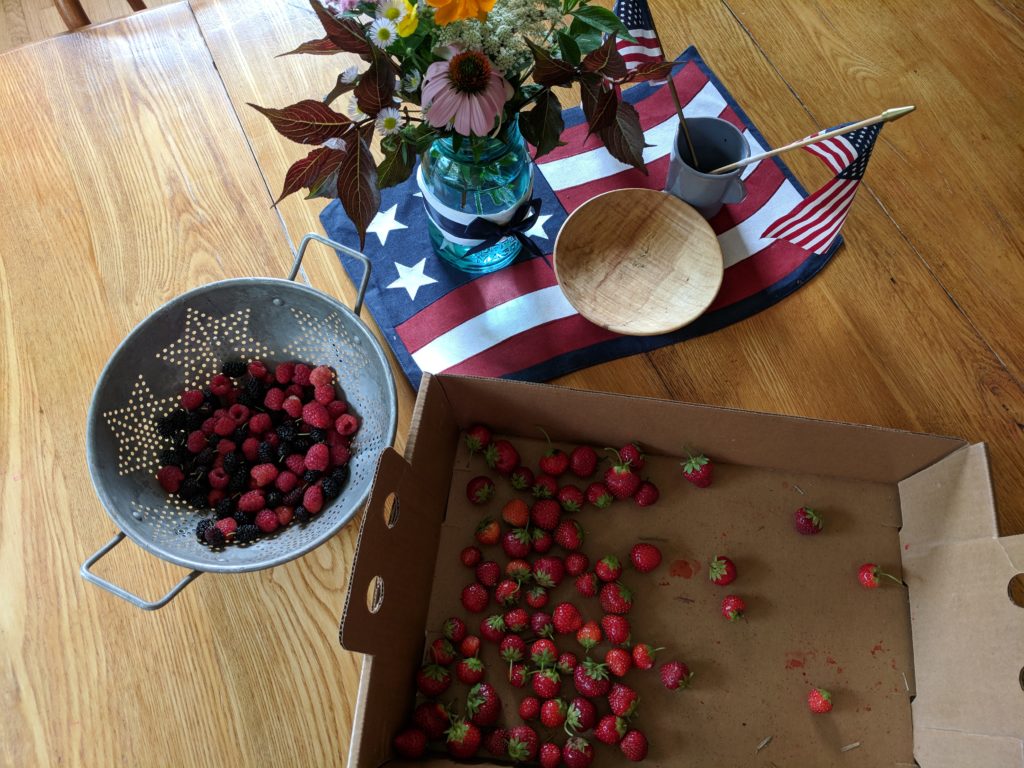 Lots of picked strawberries and raspberries.