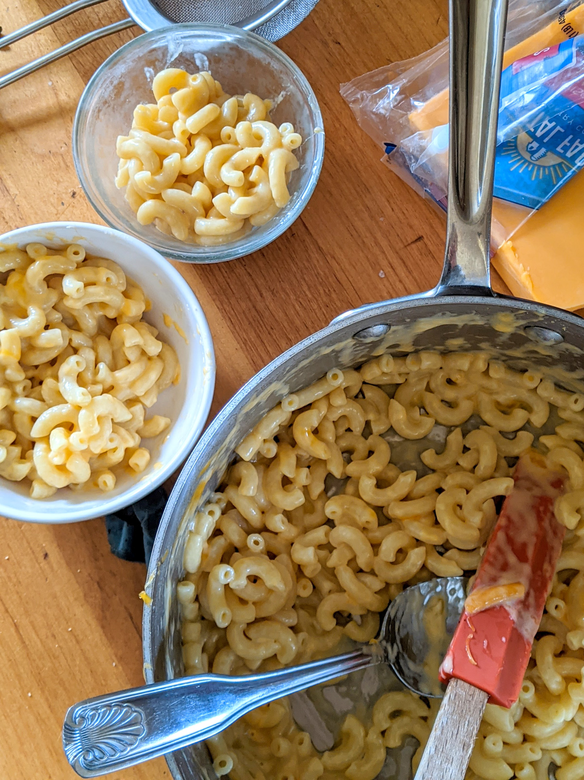 A pot and 2 kid sized bowls of quick mac and cheese.