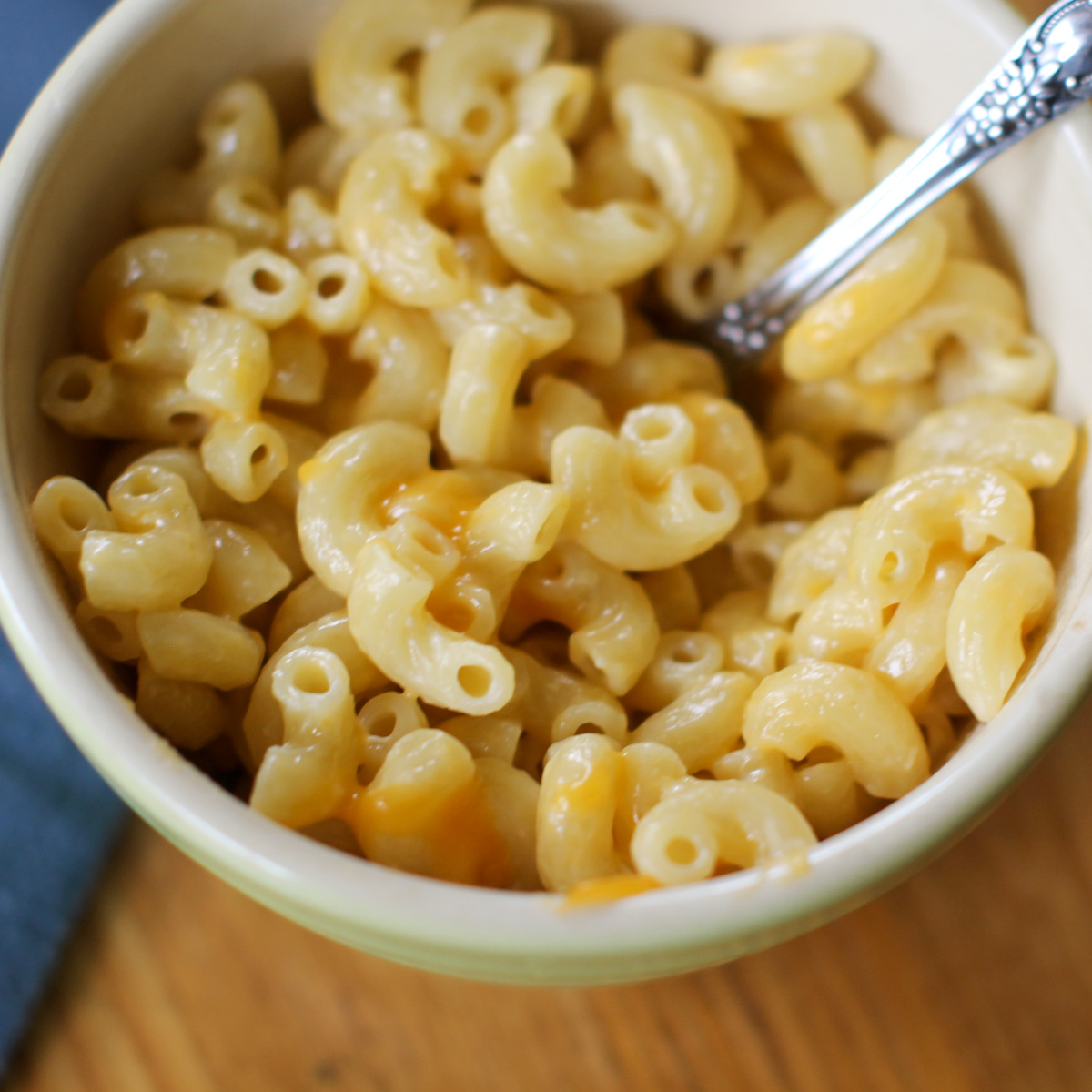 A small bowl of mac and cheese made with yogurt and shredded cheese.